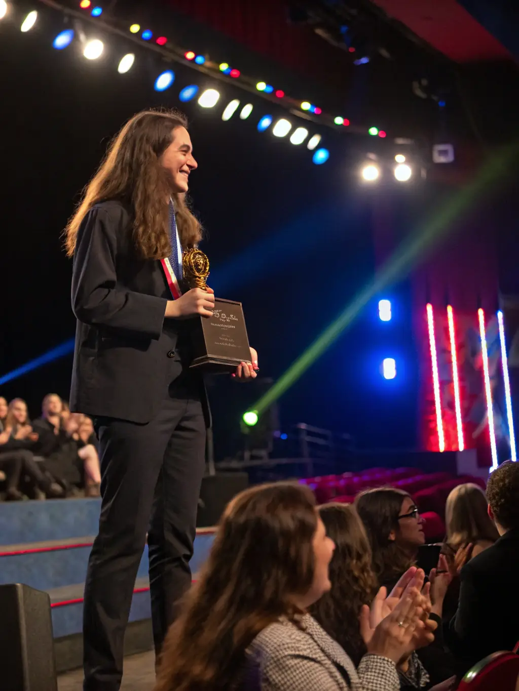 A student receiving an award at an international conference, representing the Erasmus Mundus Scholarship.